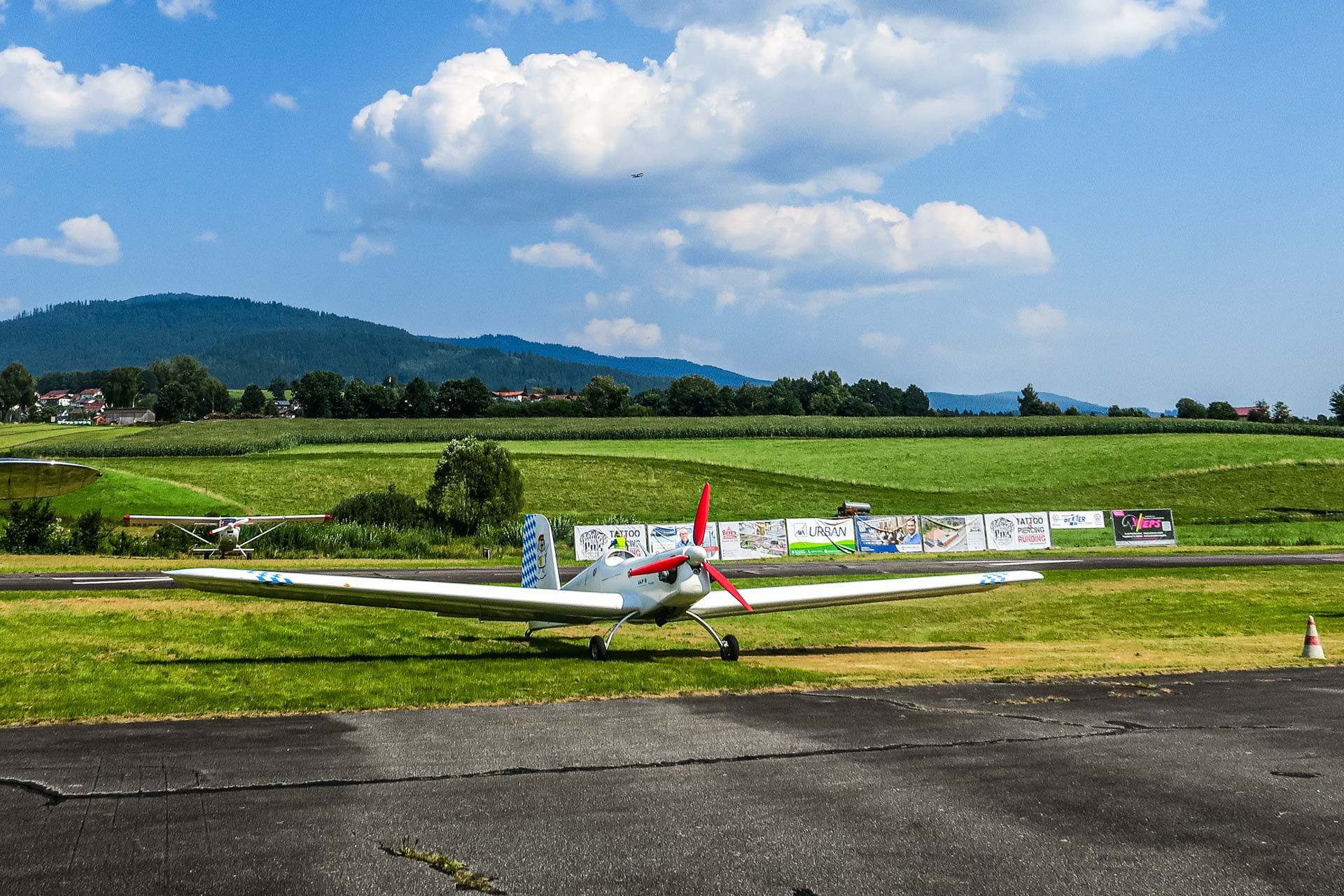 ein weißes Propellerflugzeug mit drei roten Propellerflügeln
